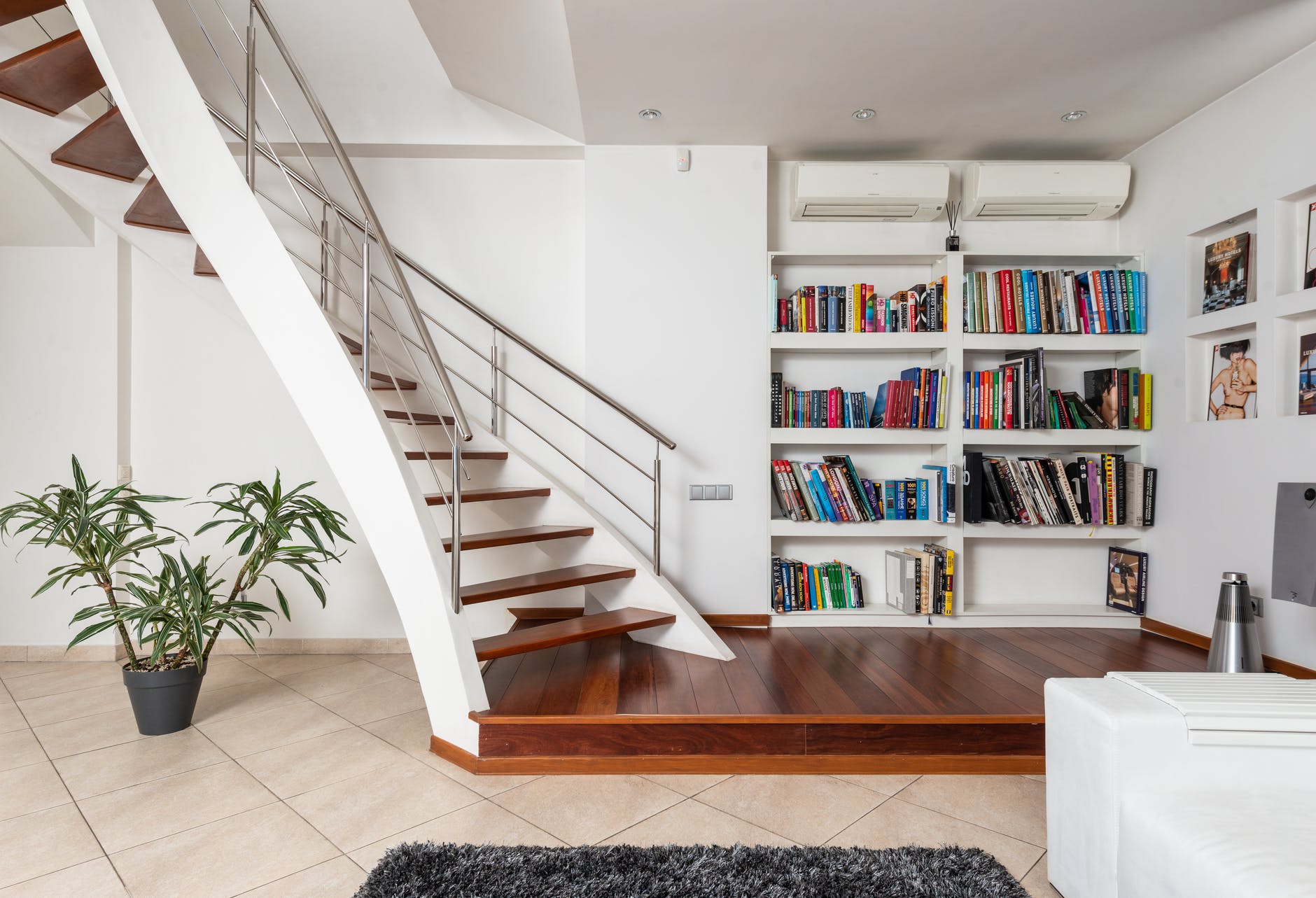 collection of books against modern stairs in house